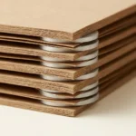 Close-up cross-section of kraft paper interleaving sheets protecting stacked precision machined parts