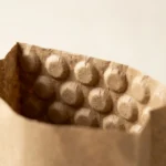 Close-up of kraft bubble paper bag opening showing embossed round-dome kraft paper inner layer and smooth kraft paper outer layer — no plastic film