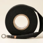 Insulating cloth tape roll with woven backing being applied over a wire connection