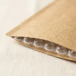 Kraft paper bubble bag inner bubble film layer detail — small-diameter PE bubble domes providing impact cushioning for shockproof packaging