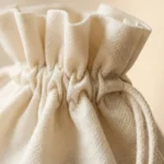 Close-up of reinforced drawstring channel on non-woven PP fabric bag — showing cord channel stitching and fiber texture detail