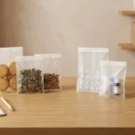 Multi-industry glassine packaging bags at distribution workstation — food, pharmaceutical, and retail applications consolidated into one paper-based packaging material