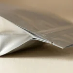 Close-up of heat-sealed edge showing PET/AL/PE laminate layer structure of aluminum foil barrier bag
